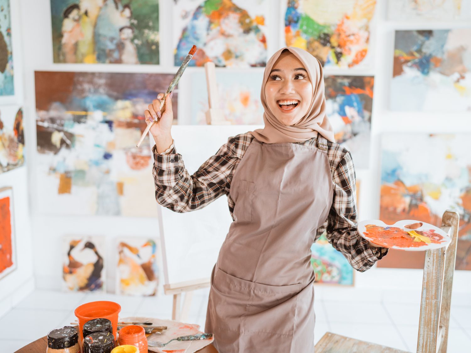 smiling painter in front of her art