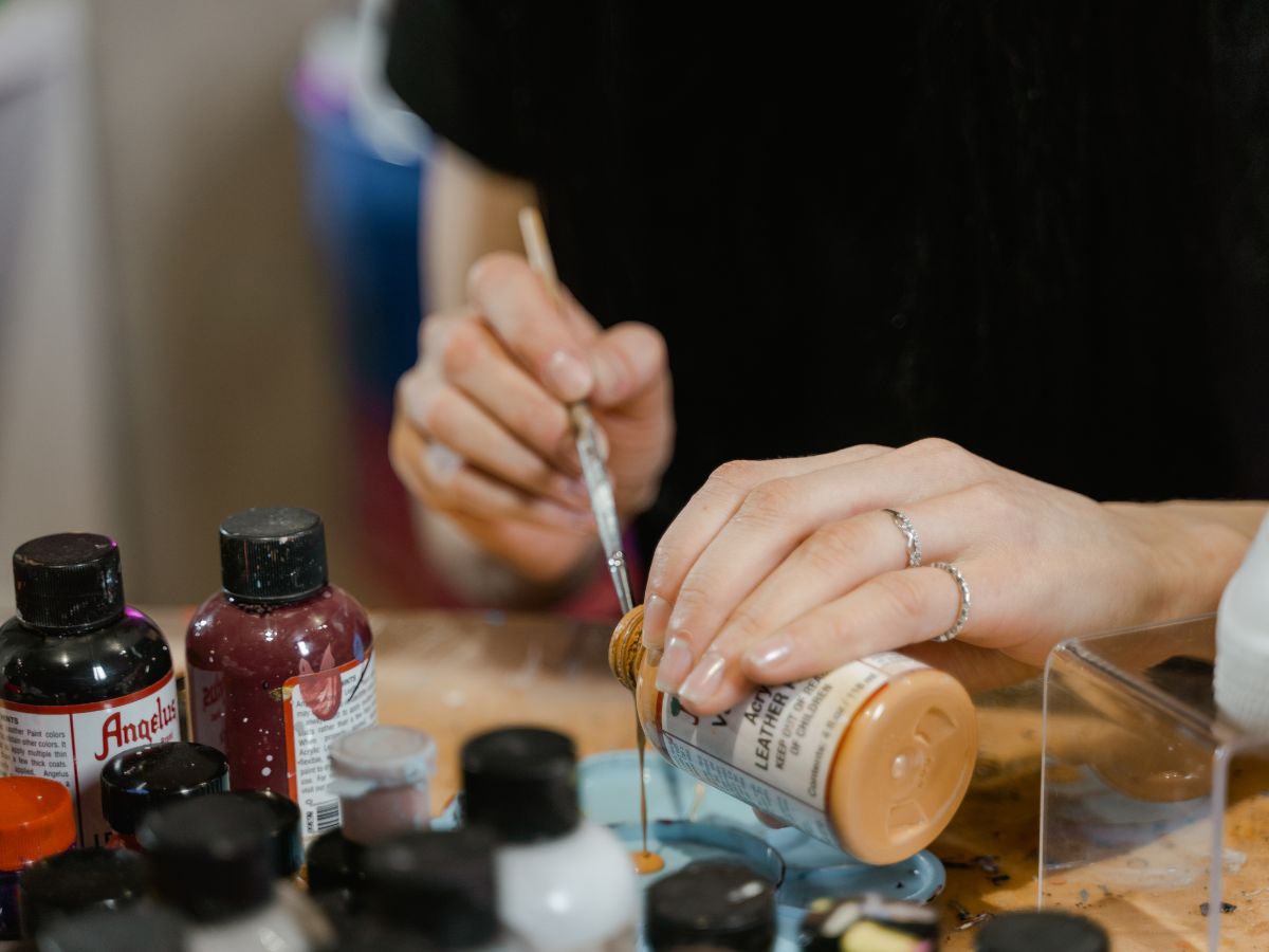 artist pouring acrylic paint on palette tray