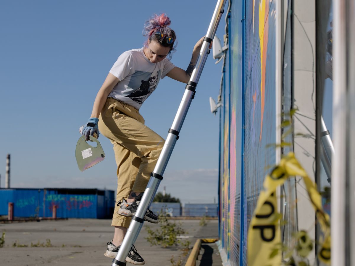 muralist climbing down a ladder