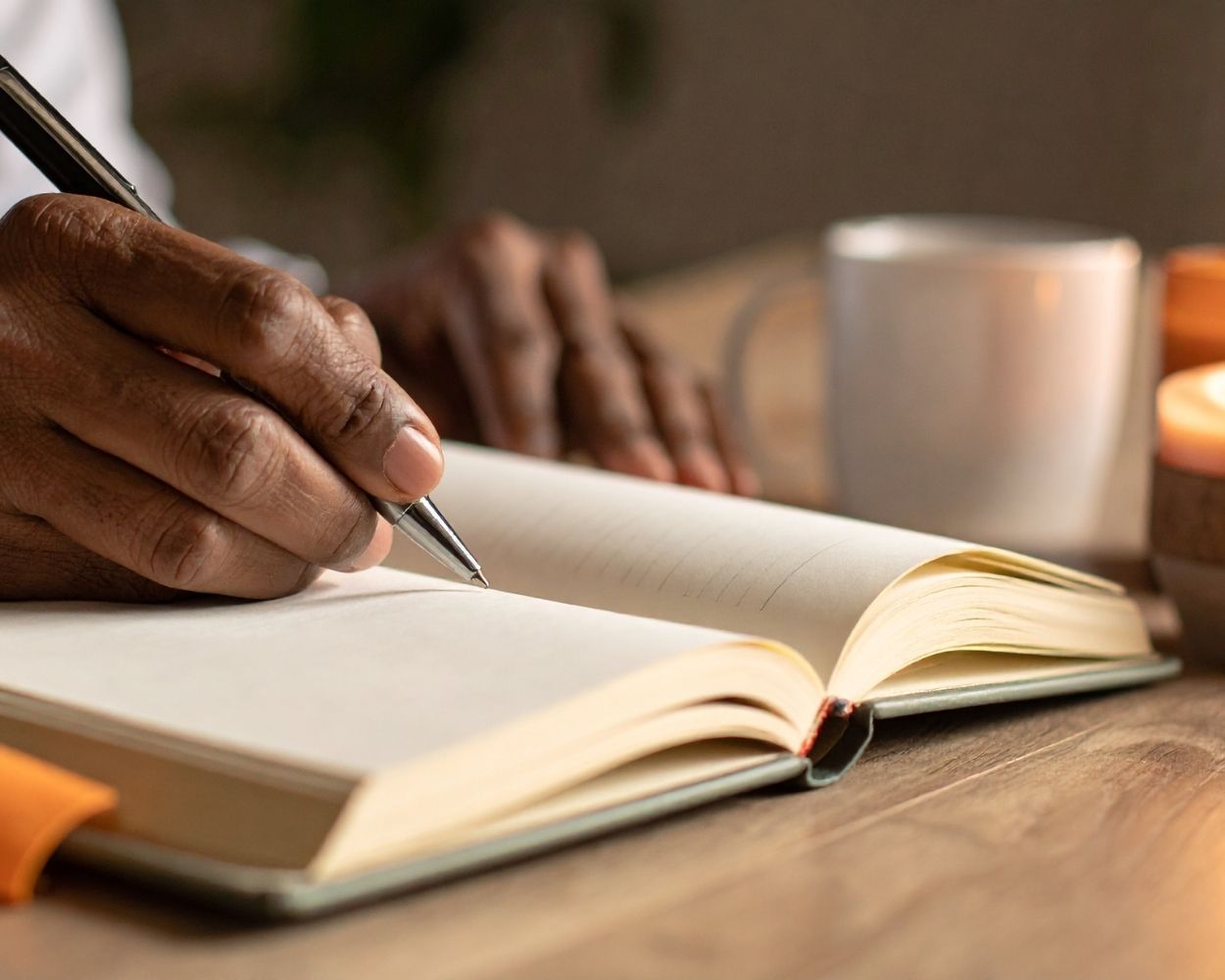 man's hand writing on an art journal