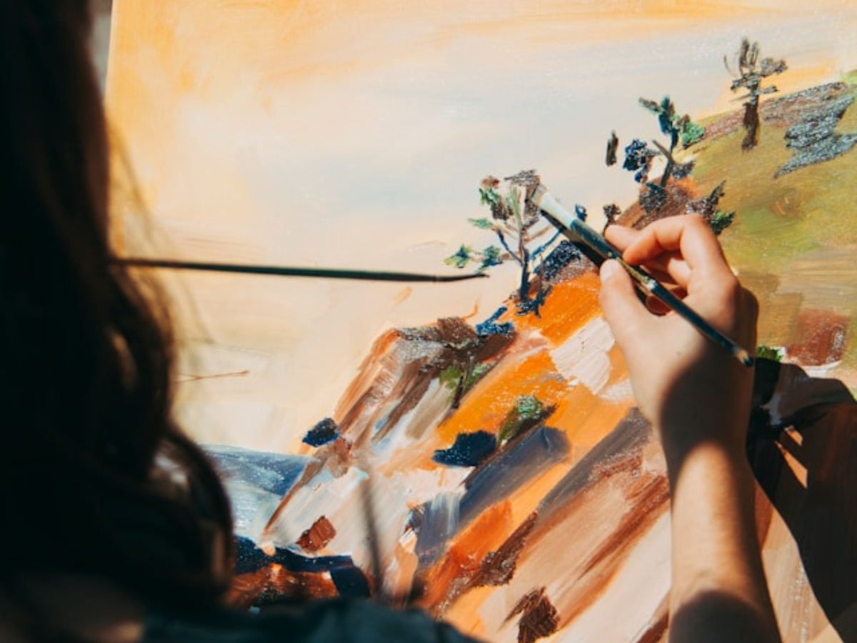 Woman painting a tree and a cliff