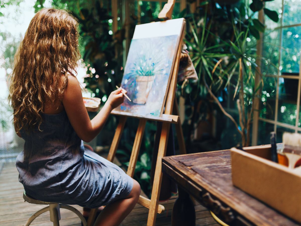 A painter paints a pot of plant with flowers