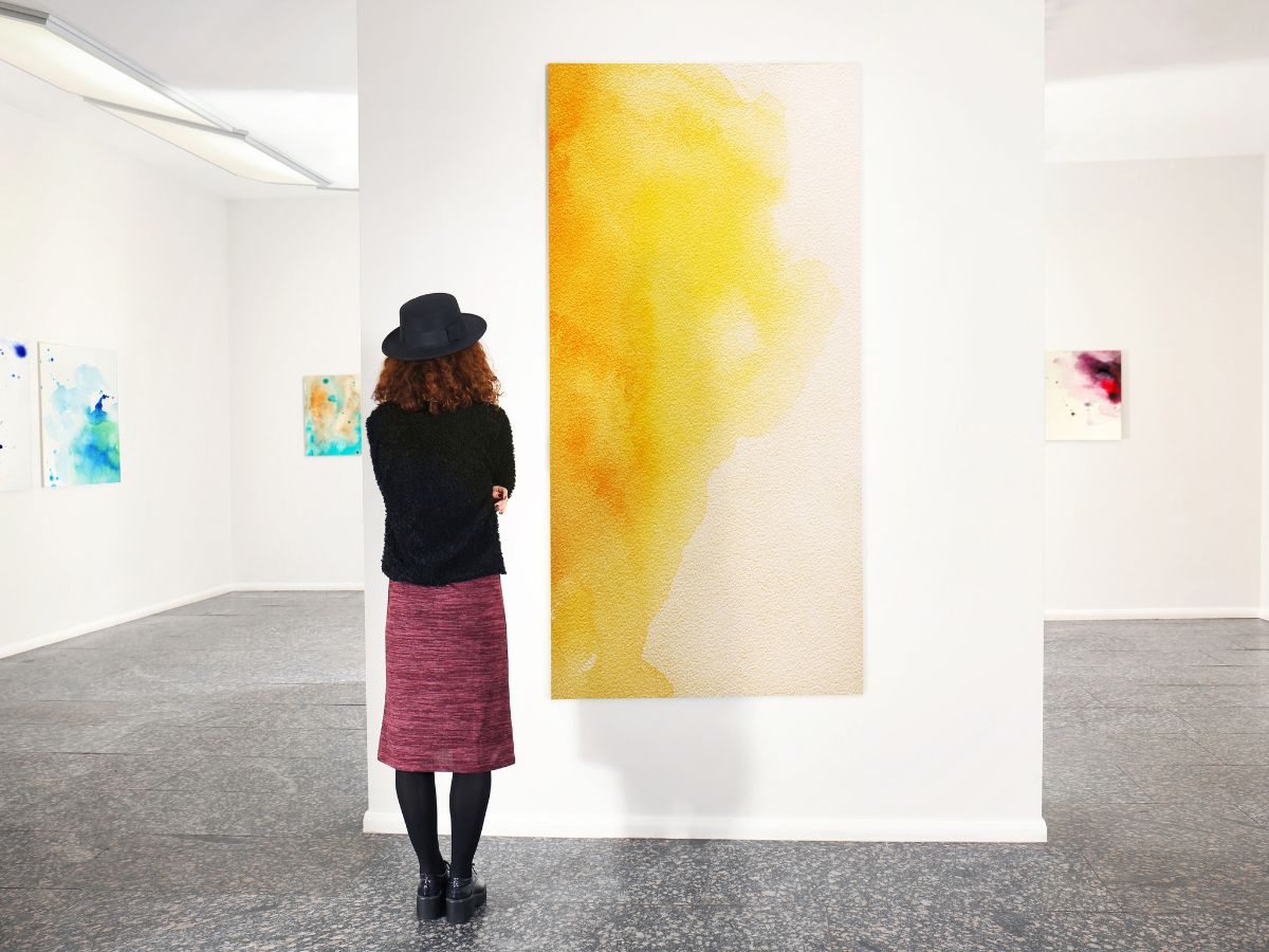 A woman looks at a contemporary painting at a gallery