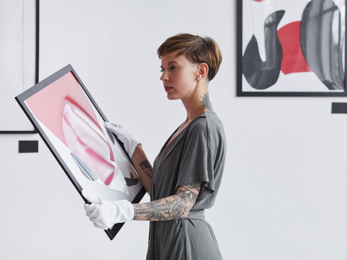 woman holding a painting in an art gallery