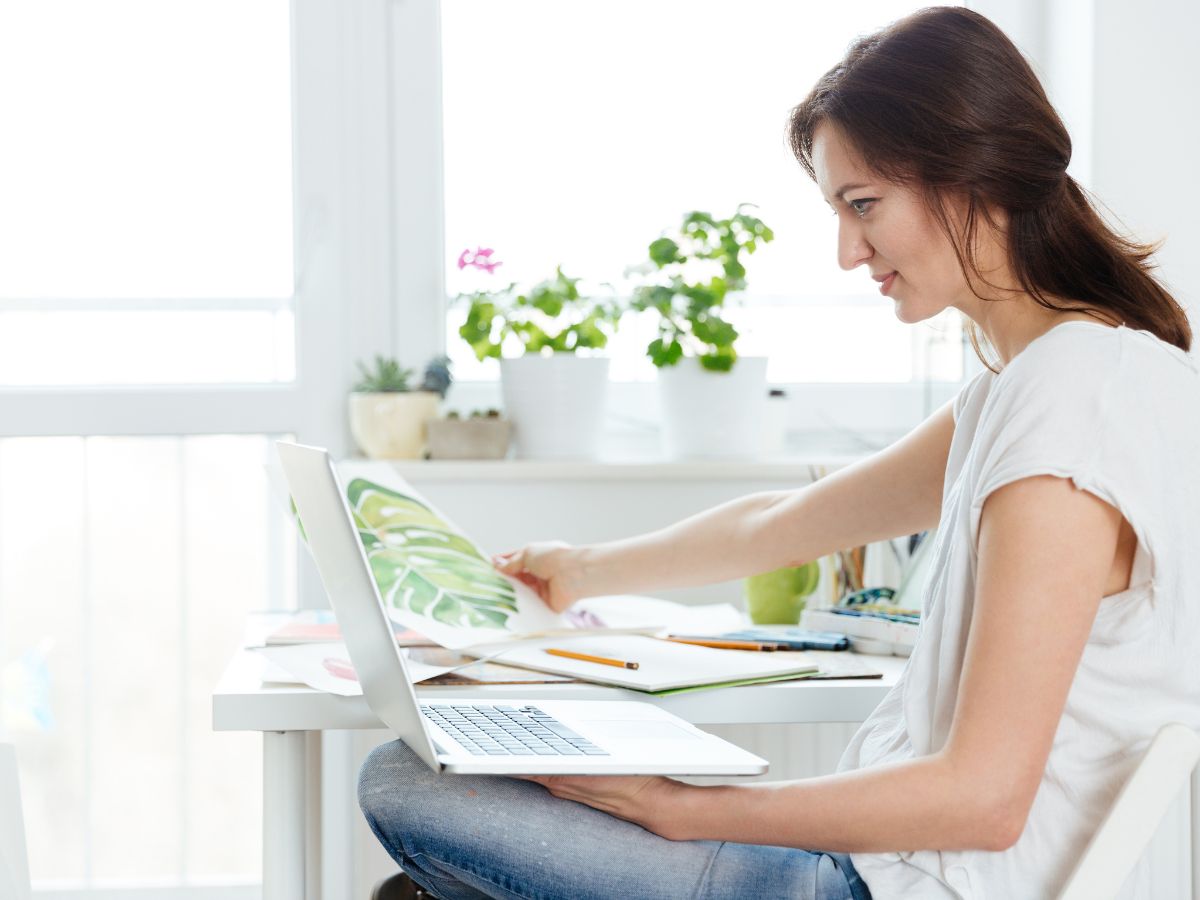 woman painter using laptop in art studio