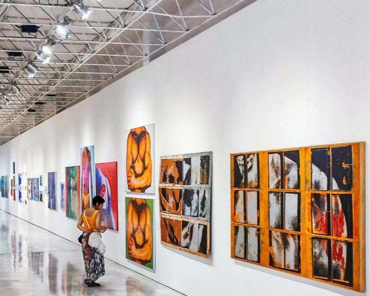 woman looking at paintings in a gallery